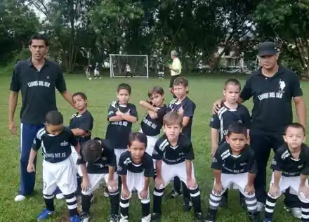 Primer equipo infantil del club, aún con el nombre Leones del Sur, junto a sus entrenadores